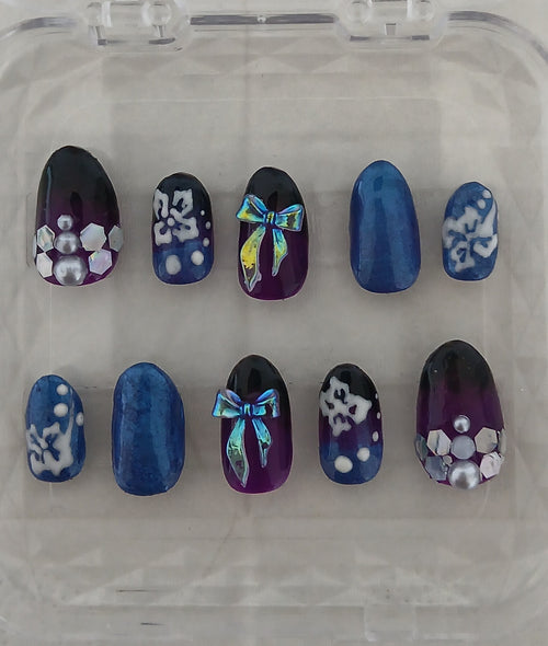 Set of decorative nails with blue, purple, and white designs on a clear background