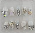 Decorative nail art with various gemstones and embellishments on a clear background