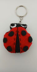 Red and black ladybug keychain on a white background